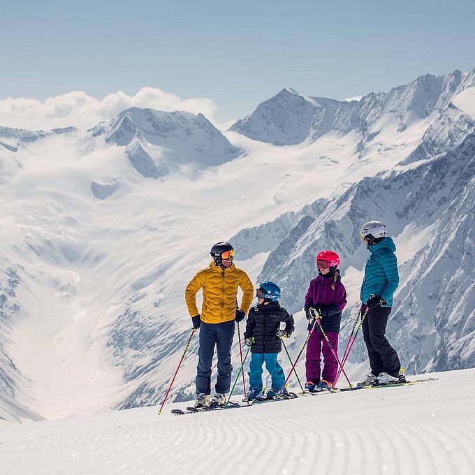 Junge Familie macht eine kurze Pause auf einer der Pisten im Tiroler Zillertal