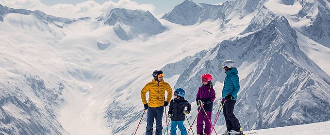 Junge Familie macht eine kurze Pause auf einer der Pisten im Tiroler Zillertal